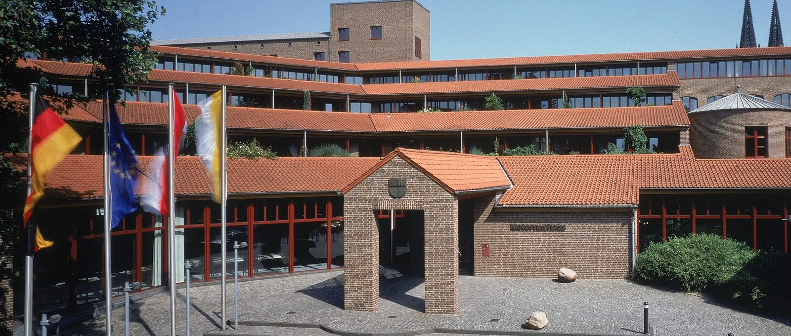 Frontalansicht des Haupteingangs  mit Treppenaufgang bei wolkenlosem Himmel des Maternushaus in der Kölner Innenstadt