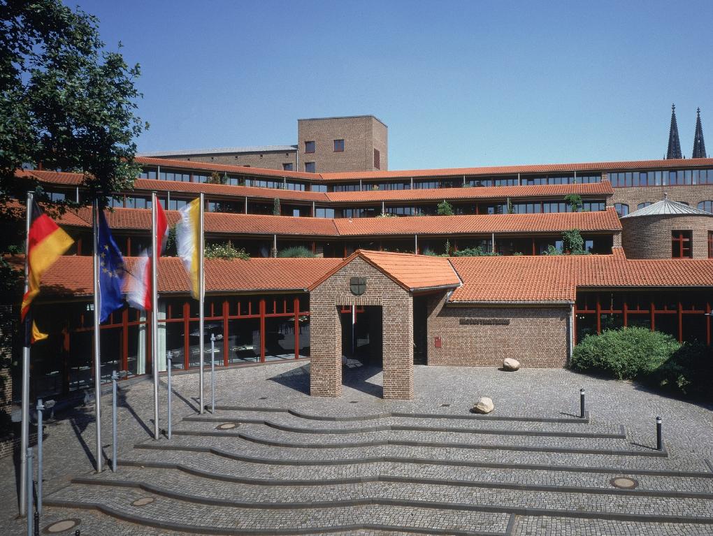 Frontalansicht des Haupteingangs  mit Treppenaufgang bei wolkenlosem Himmel des Maternushaus in der Kölner Innenstadt