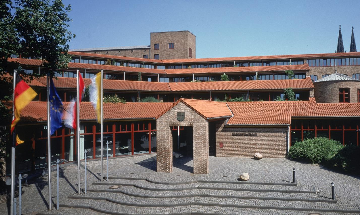 Frontalansicht des Haupteingangs  mit Treppenaufgang bei wolkenlosem Himmel des Maternushaus in der Kölner Innenstadt