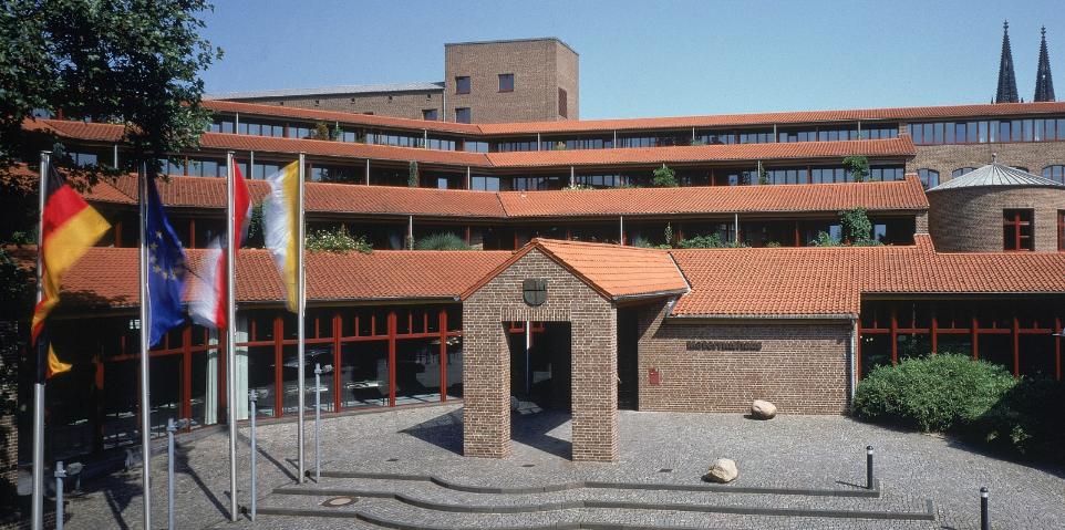 Frontalansicht des Haupteingangs  mit Treppenaufgang bei wolkenlosem Himmel des Maternushaus in der Kölner Innenstadt